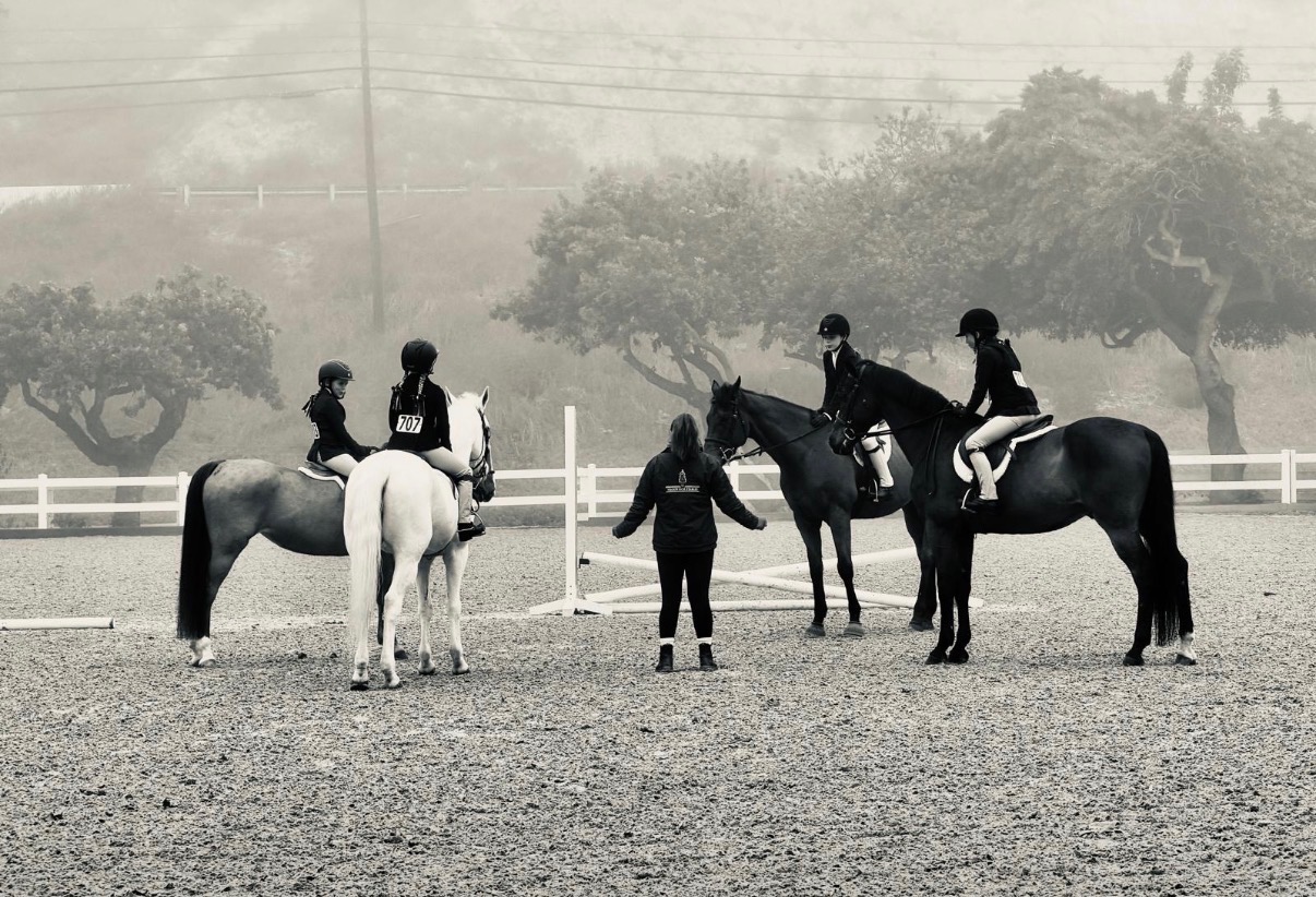instructor with students during hunter jumper training lesson